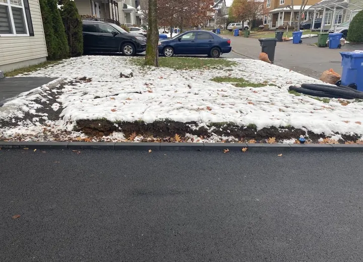 Installation d'une bande linéaire dans la ville de Québec pour délimiter une entré d'Asphalte.
