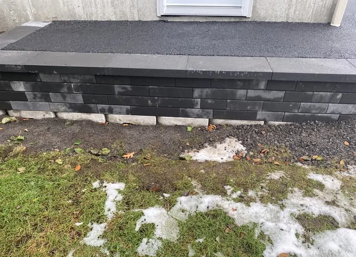 Travaux de construction de muret en dalle avec finition en asphalte dans la Ville de Québec